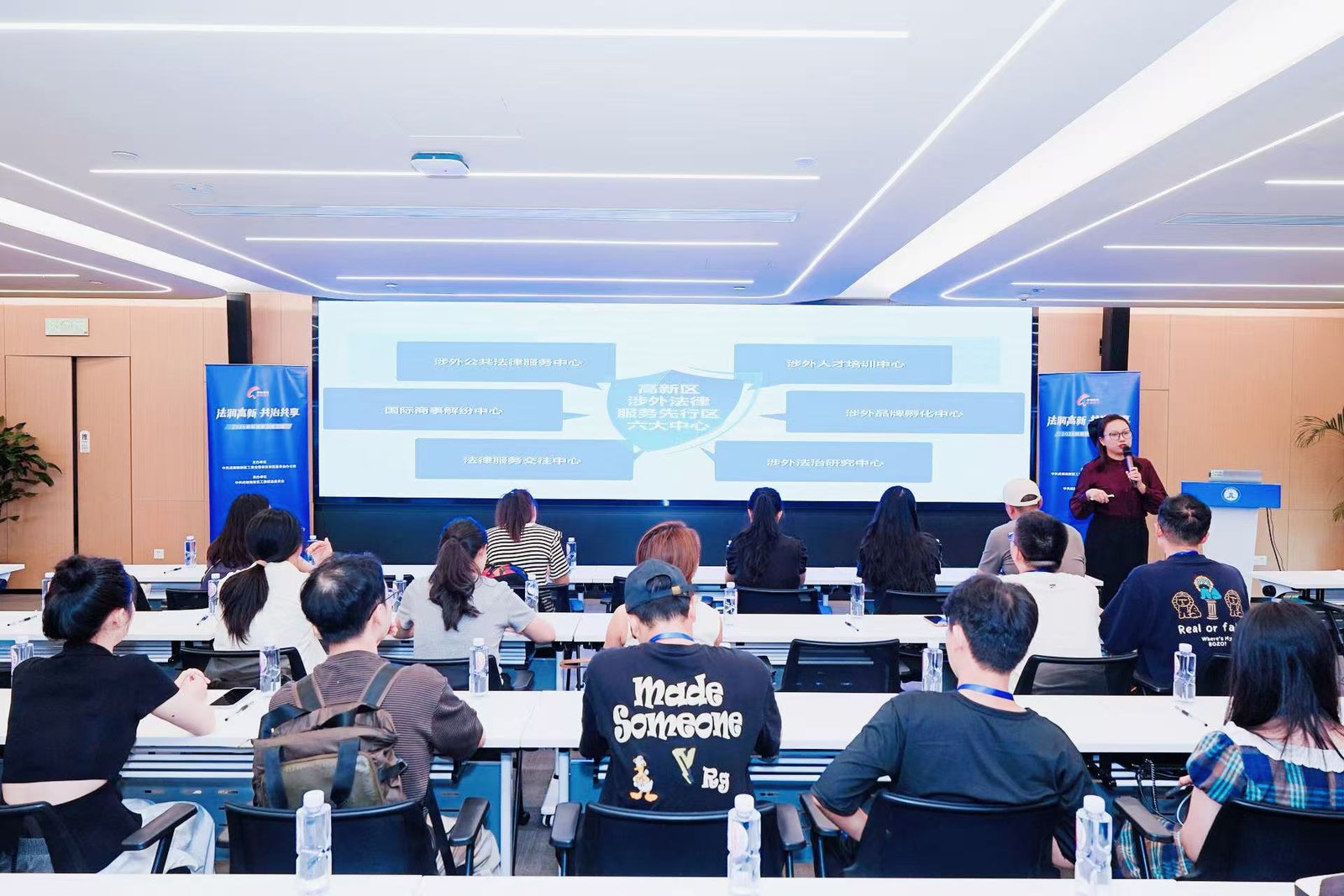 Fan Zhang presenting the six functional centers of Chengdu High-Tech Zone's foreign-related rule-of-law framework at the 2026 Rule of Law Tour